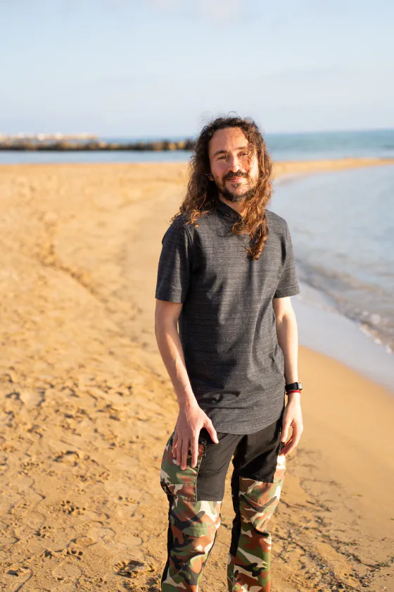 Oscar Gallo in piedi sulla battigia a San Leone, in maglia scura, con il mare alle spalle.